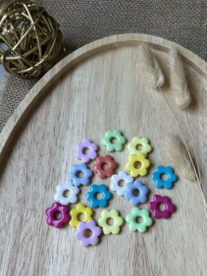 LEA uni Pampilles en forme de petites fleurs dentelées multicolores de la gamme Léa pour boucles d'oreilles interchangeables Nohulé Création sur un plateau en bois.